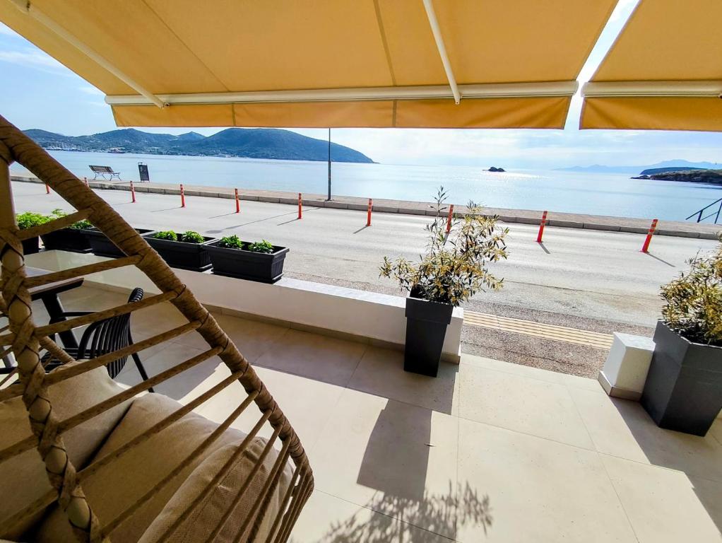 a balcony with a view of a beach with potted plants at Aurora suite in Nea Peramos