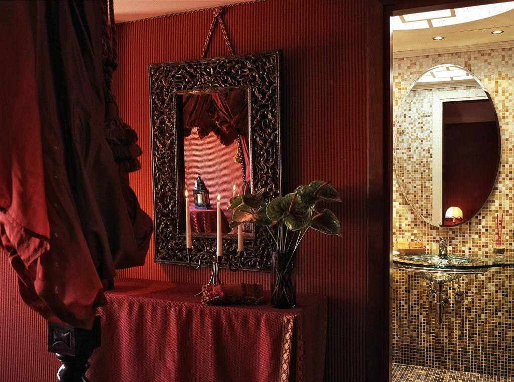 a red room with a table and a mirror at Hotel Metropole Venezia in Venice