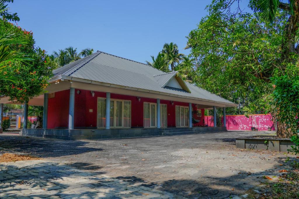 a red house with a red at Mannath Lake House in Murinjupuzha