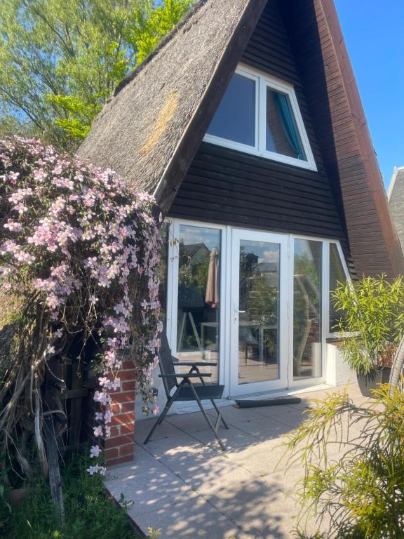 a house with a thatched roof and a patio at Ferienhaus nähe Warnemünde 3 in Elmenhorst