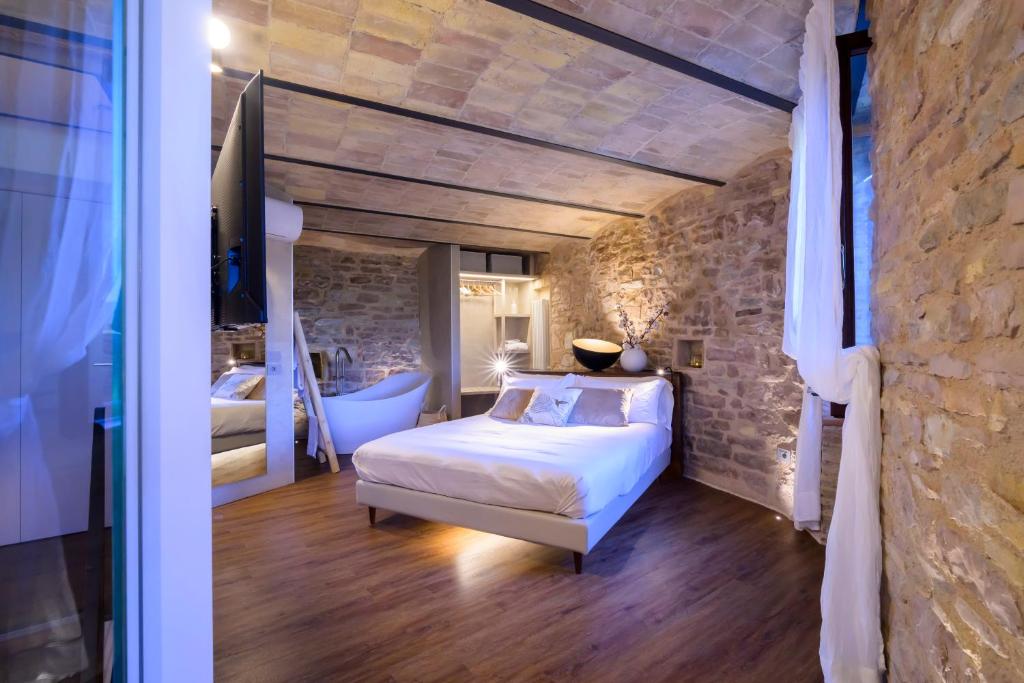 a bedroom with a bed and a stone wall at Charme in Spello in Spello