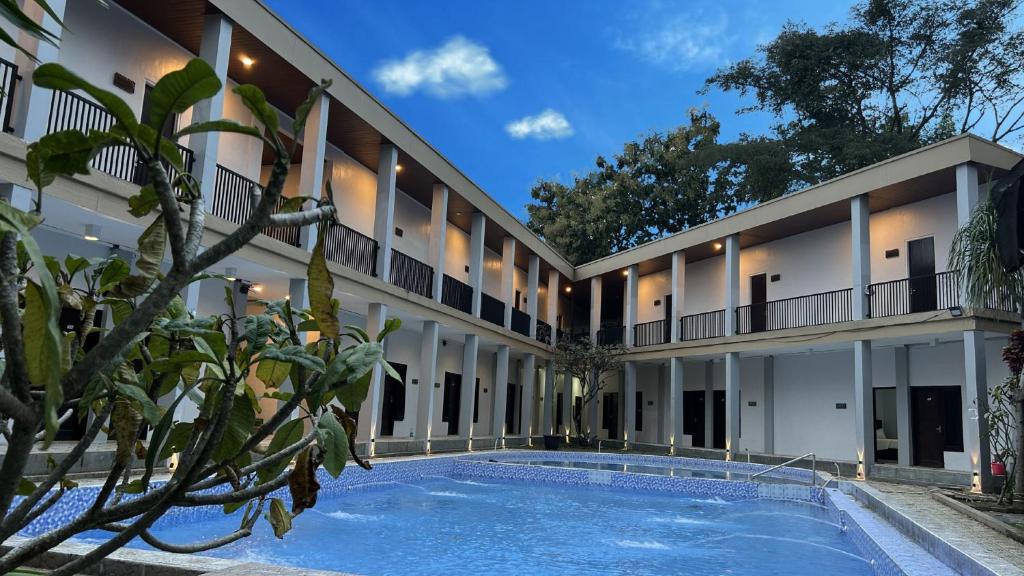 an exterior view of a building with a swimming pool at Bwalk Hotel & Villa Malang in Sengkaling