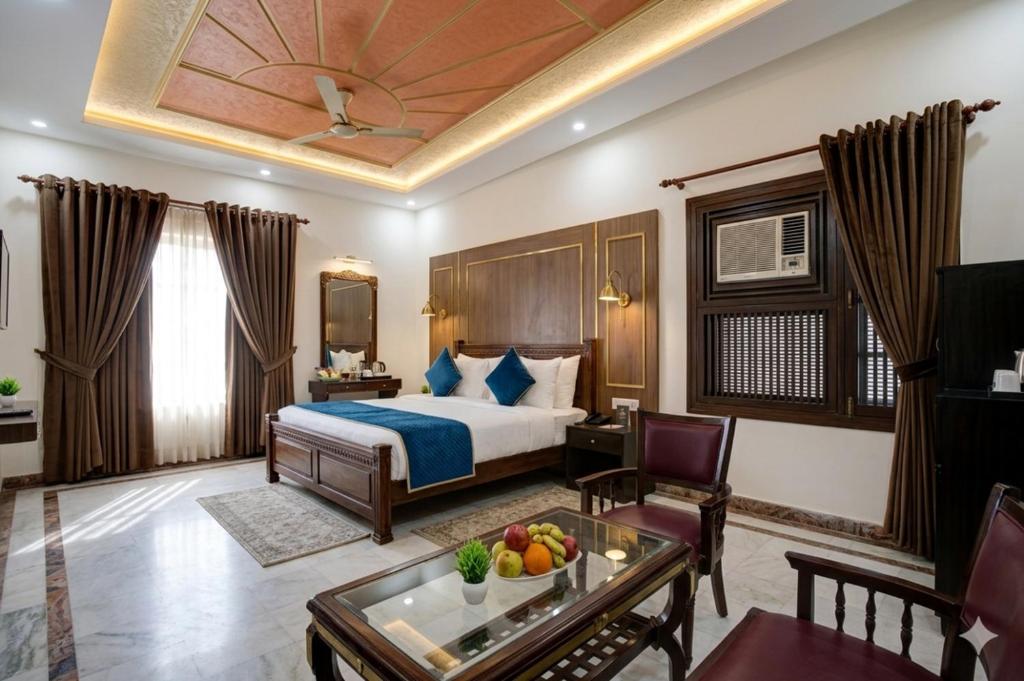 a hotel room with a bed and a table at Hotel Royal Prithvi Palace Near Ghaziabad Railway Station in Ghaziabad