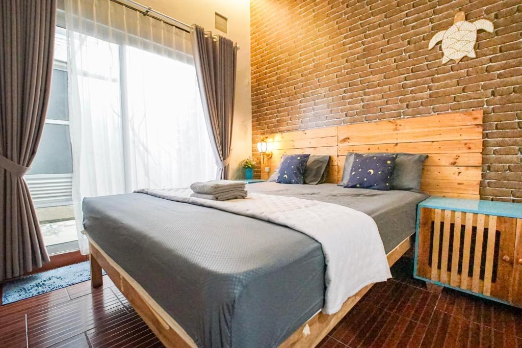 a bedroom with two beds and a brick wall at Citra Condong Catur in Seturan