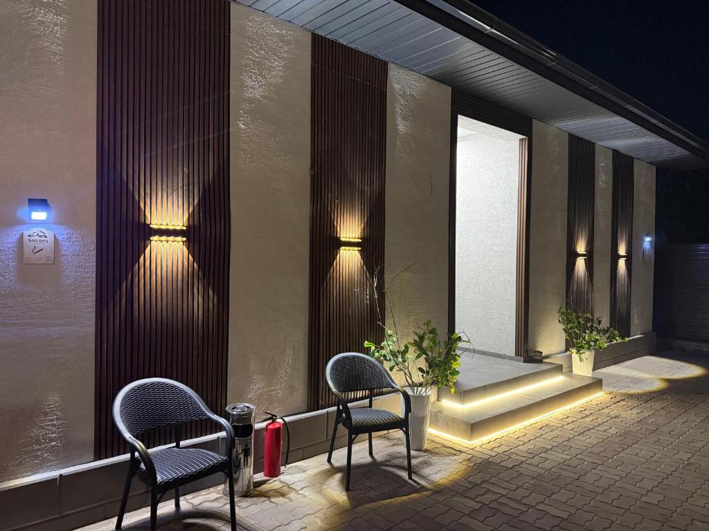 a waiting room with two chairs and lights on the wall at Sherpa space in Almaty