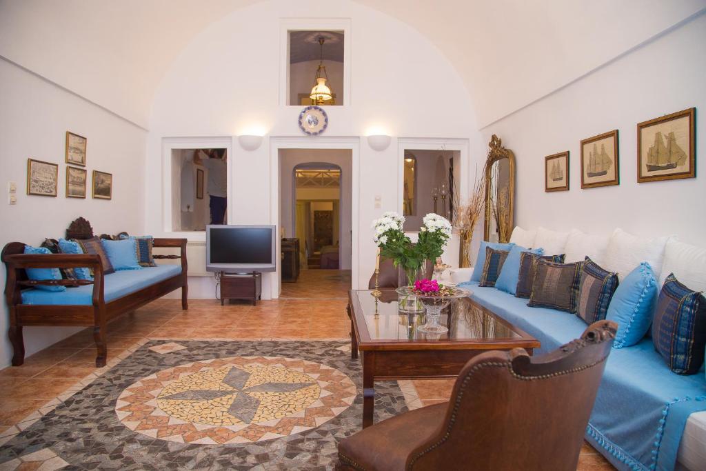 un soggiorno con divano blu e tavolo di Lydia Luxury villa a Karterados