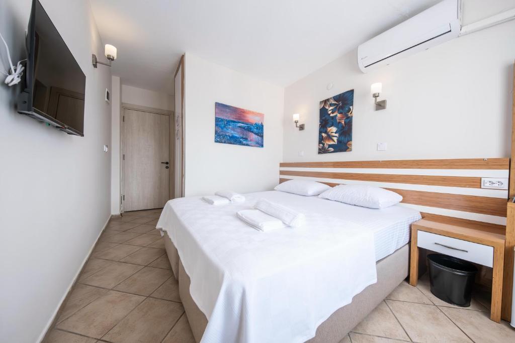 a bedroom with a large bed and a flat screen tv at SUNMARİS CİTY HOTEl in Marmaris