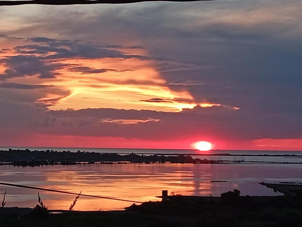 a sunset over a body of water at villa sun view in Peratiá