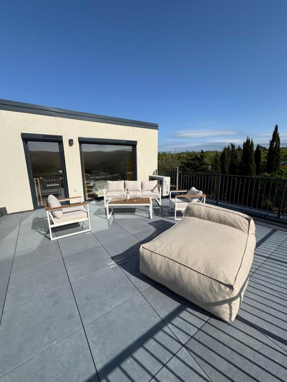a patio with couches and chairs on a roof at Villa Quartura in Kornić