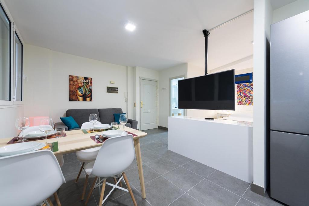 a kitchen and living room with a table and a tv at Suites Garden Apartamento 12 in Las Palmas de Gran Canaria