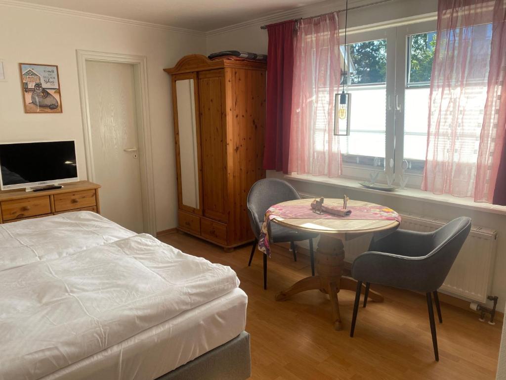 a bedroom with a bed and a table and a window at Sylvie Steinhardt, Wohnung 3 in List