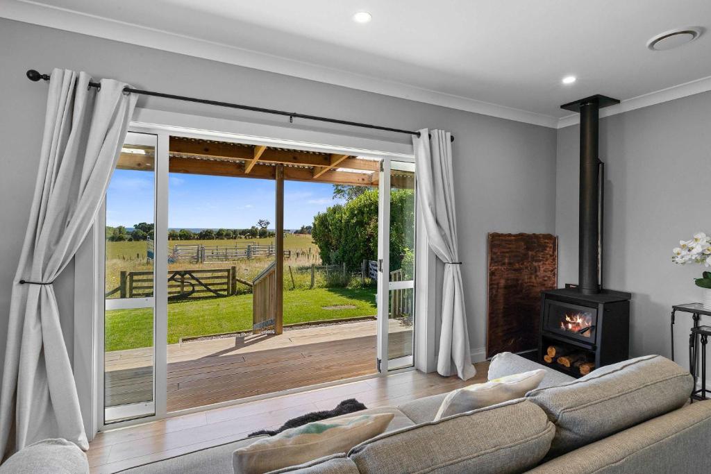 a living room with a couch and a fireplace at Weld Cottage - Sustainable lifestyle property in New Plymouth