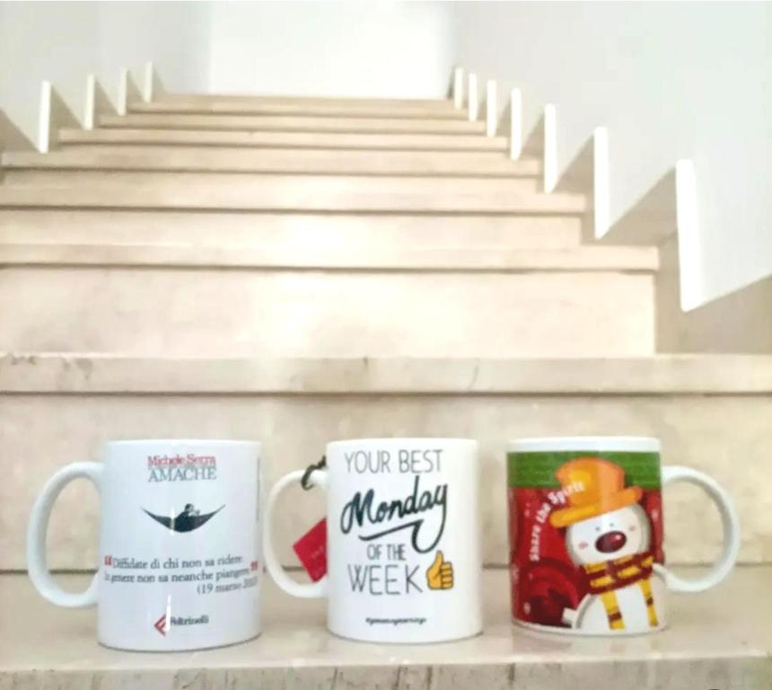 a couple of coffee mugs sitting on a shelf at La Stanza nella corte in Bollate