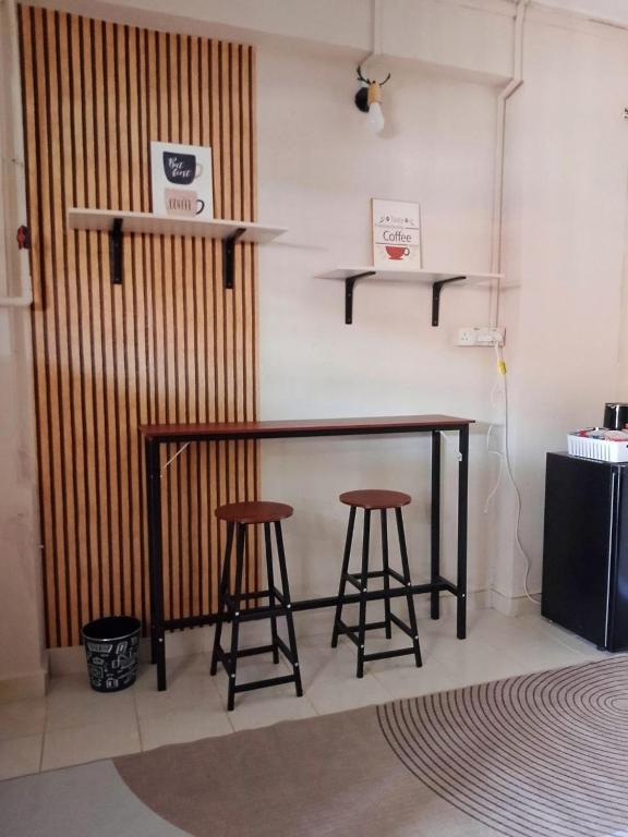 a bar with two stools in a room at Tipika Room Pasir Pekan in Tumpat