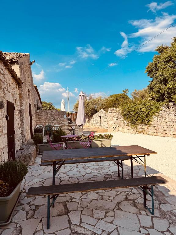 a picnic table with an umbrella on a stone patio at Casa Betta in Modica