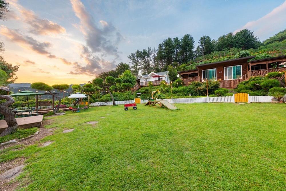 a large yard with a playground and a house at Gapyeong Petmily Dog Pension in Gapyeong