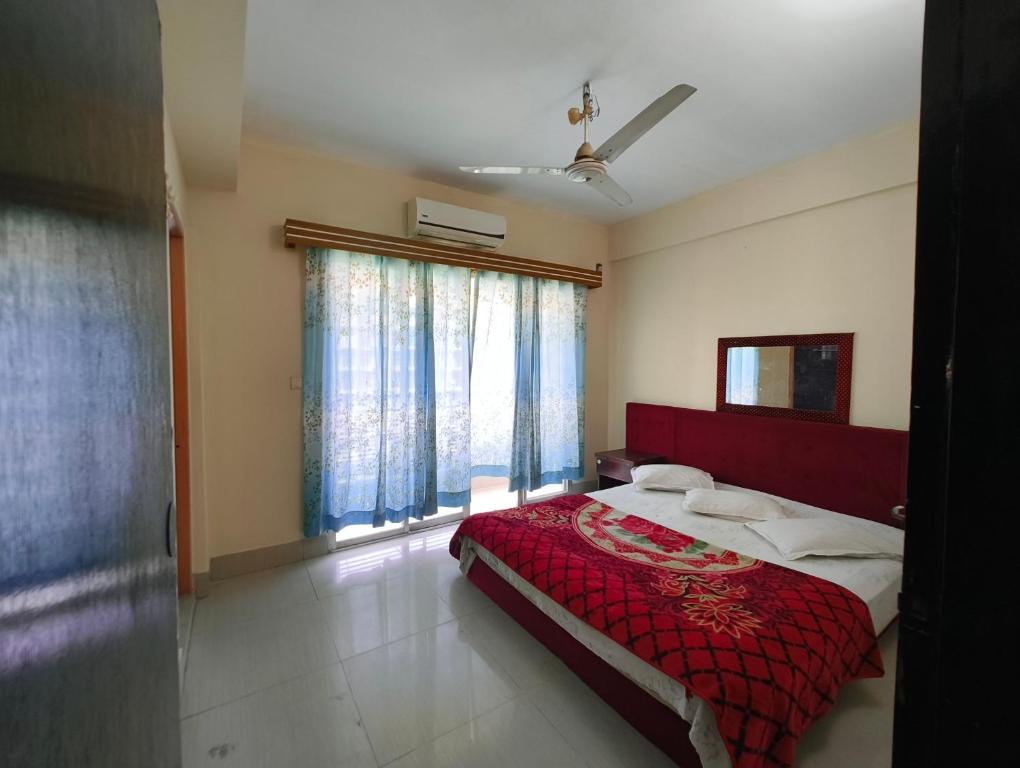 a bedroom with a red bed with a red blanket at Hotel World Beach Resort in Cox's Bazar