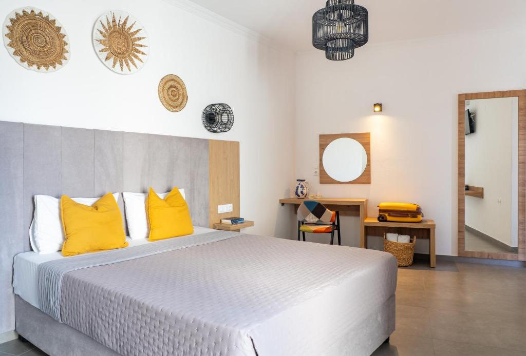 a bedroom with a large white bed with yellow pillows at Cactus in Skiathos