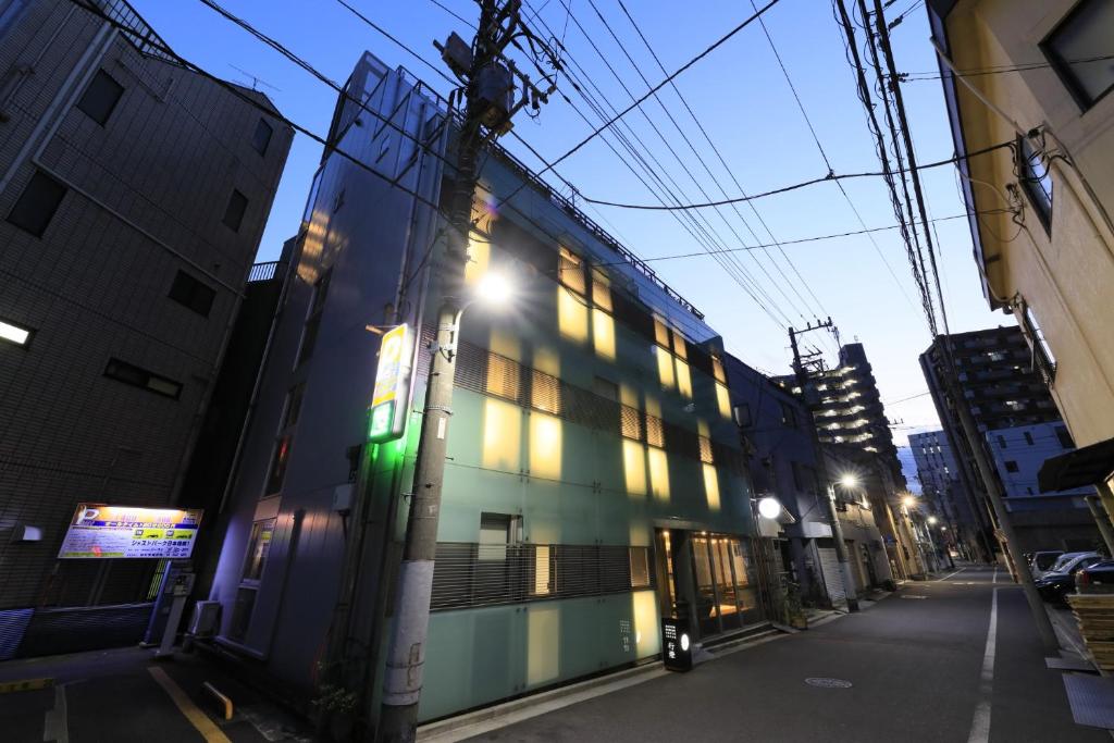 a building with a green light on the side of it at Andon Ryokan in Tokyo