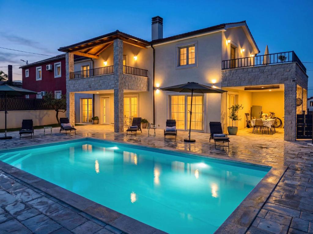 a swimming pool in front of a house at Villa Gaudeo with pool and EV station in Nova Vas
