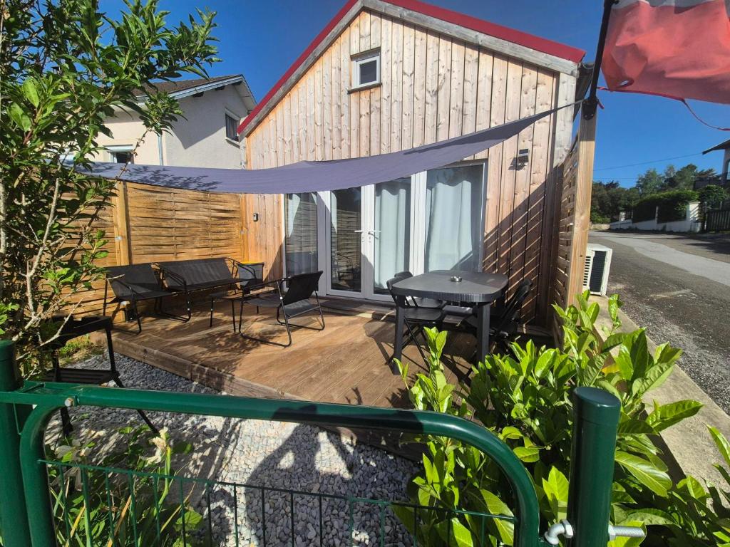 a patio with a table and chairs and a building at Le Ptit Châlet de Monnet in Monnet-la-Ville