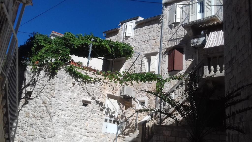 a stone building with potted plants on top of it at Apartments Donika in Komiža