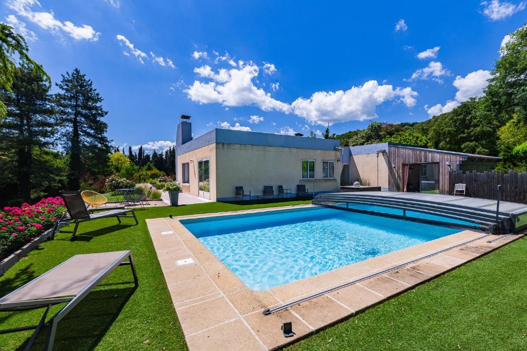 a swimming pool in the yard of a house at Villa Montplaisir 180m² - Jacuzzi in Charmes-sur-Rhône