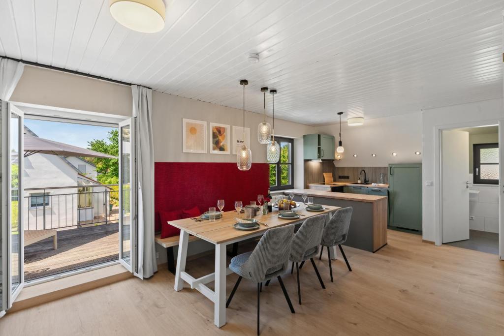 a kitchen and dining room with a table and chairs at Das BRIX I Apartments zwischen See & Wald in Immenstaad in Immenstaad am Bodensee