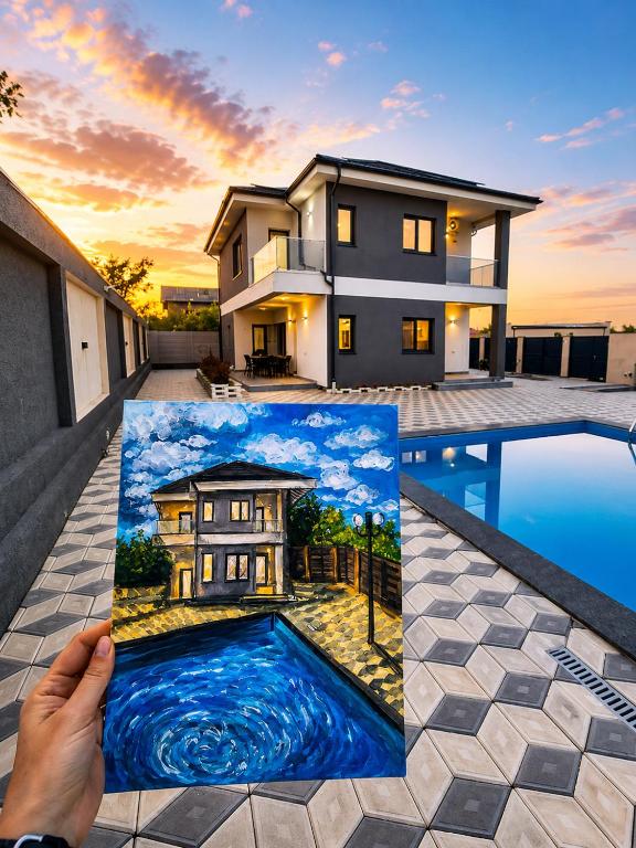 a person holding a picture of a house at Grey House in Bucharest