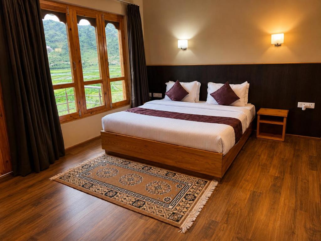 a bedroom with a bed and a large window at hotel pema kara in Paro