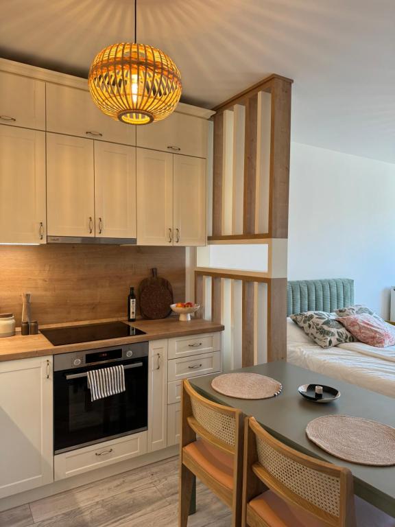 a kitchen with a table with chairs and a bed at Edison Villa 214 in Fonyód