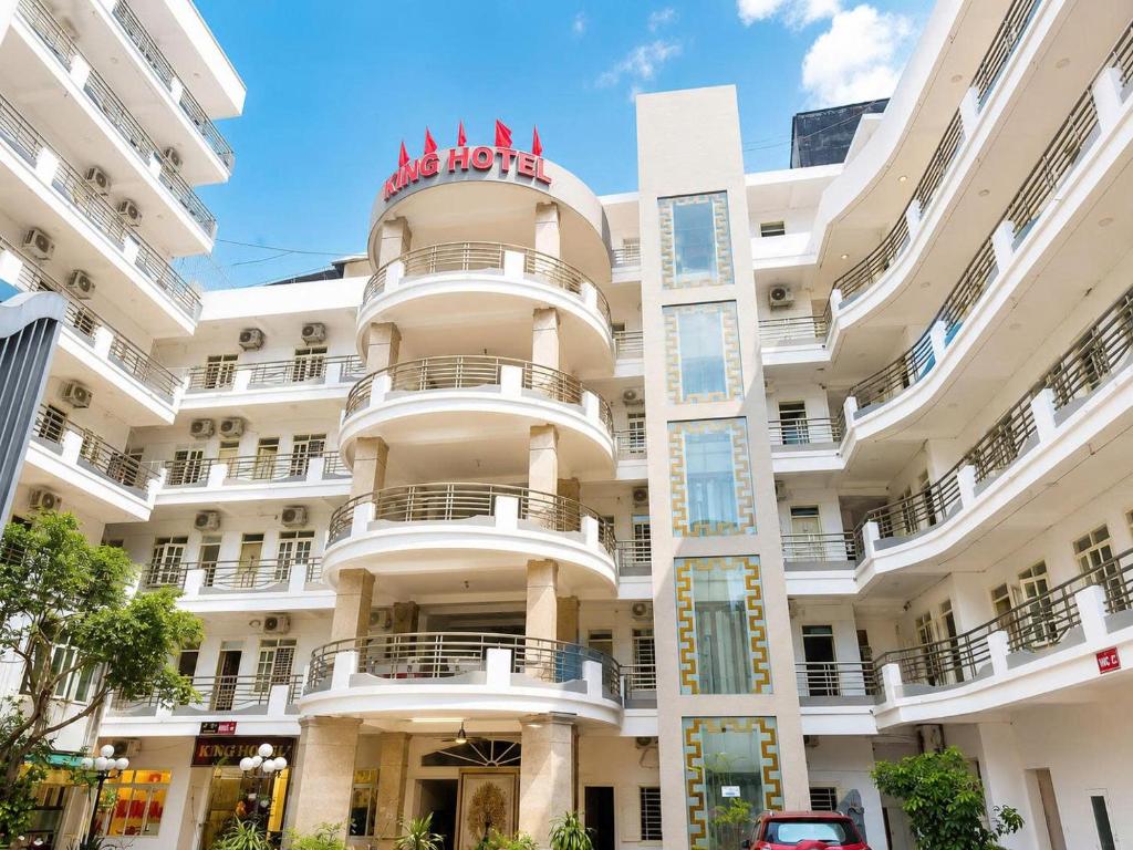 a white building with a red sign on it at King Hotel Sầm Sơn in Sầm Sơn