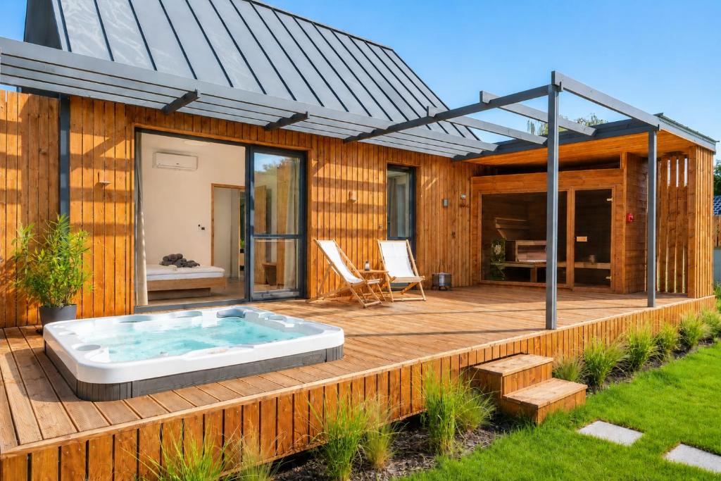 a house with a hot tub on a wooden deck at Natur Harmony Tiszafüred in Tiszafüred