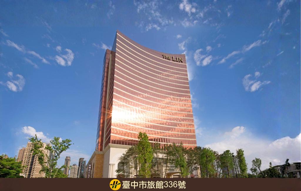 a tall building with the sun reflecting on it at THE LIN Hotel in Taichung