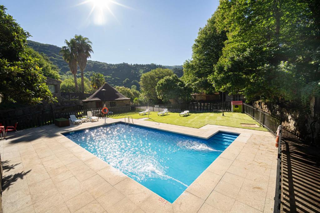 a swimming pool in a yard with a fence at Chozos Rurales El Solitario in Baños de Montemayor