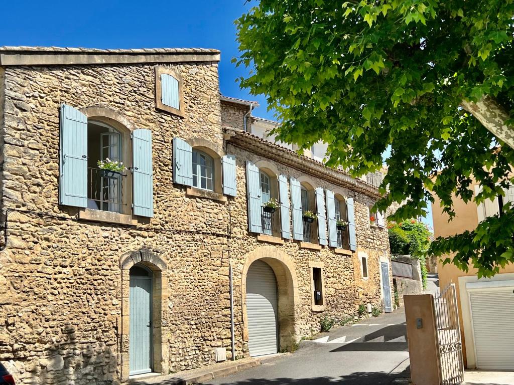 an old brick building with white windows and doors at La Villa 1777 in Lagnes