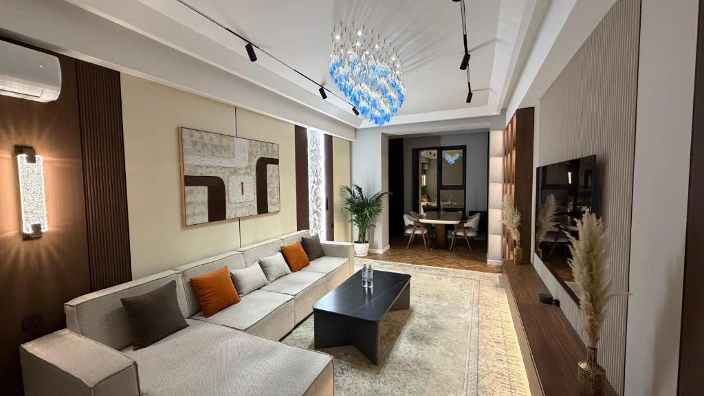 a living room with a couch and a table at Zafran Smart Luxury Suite in Dushanbe