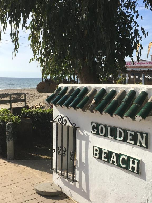 マルベーリャにあるGolden Beachの海を背景にした黄金の浜辺の看板