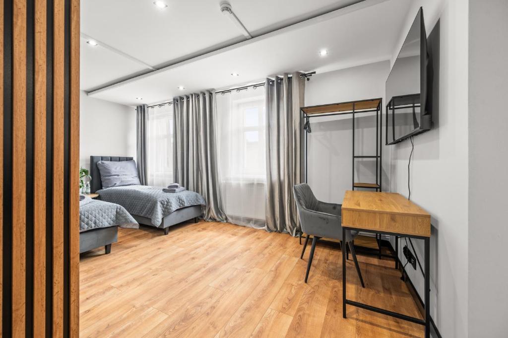 a bedroom with a bed and a desk in a room at Central Platinum Apartments 13 in Rybnik
