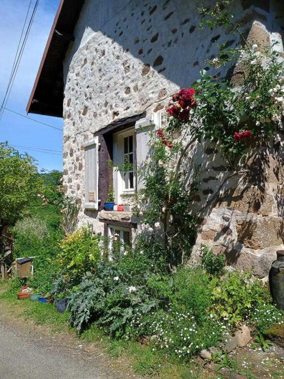 a stone house with flowers on the side of it at Les Cavaleries in Nonards