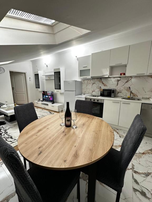 a wooden table in a kitchen with a bottle of wine at Stan na dan in Obrenovac