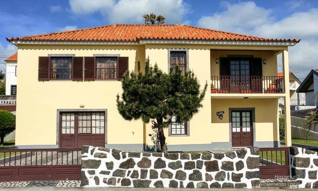 a yellow house with a tree in front of it at Hospetur 2 in Horta