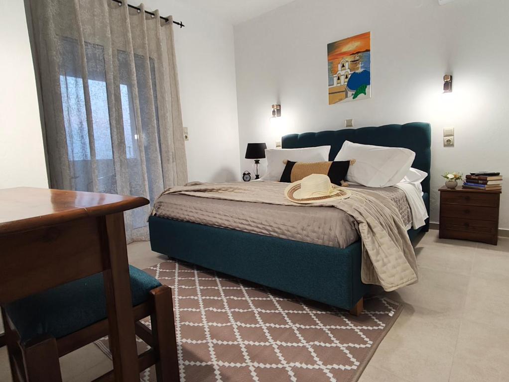 a bedroom with a blue bed and a table at Prikas Apartments B in Kefalos