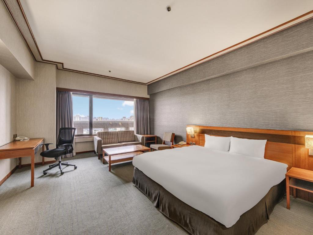 a hotel room with a large bed and a desk at Guide Hotel Hsinchu Zhongyang in Hsinchu City