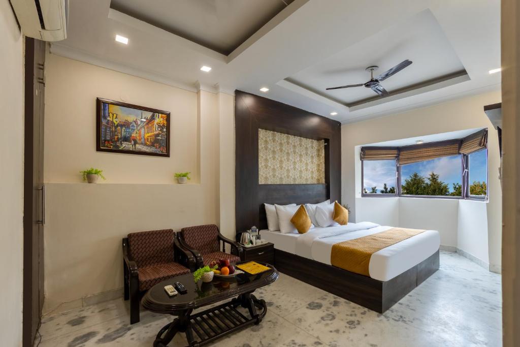 a hotel room with a bed and a table at Hotel Dharam Villa By Jai Guru Ji At Sector 11, Noida in Noida