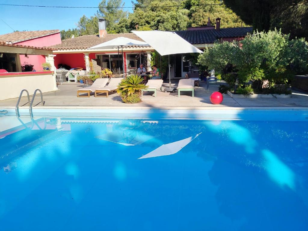 a swimming pool in front of a house at Au Mas Saint Pierre - Chambres d'hotes de charme et gite in Pignans