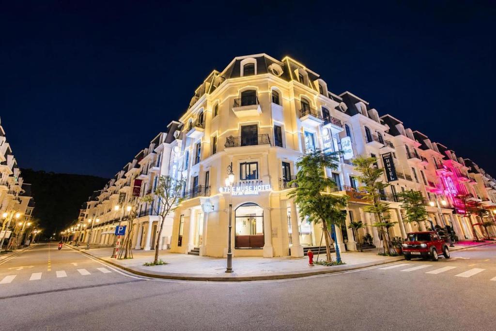 a large white building on a city street at night at The Muse Hotel 2 in Ðố Sơn