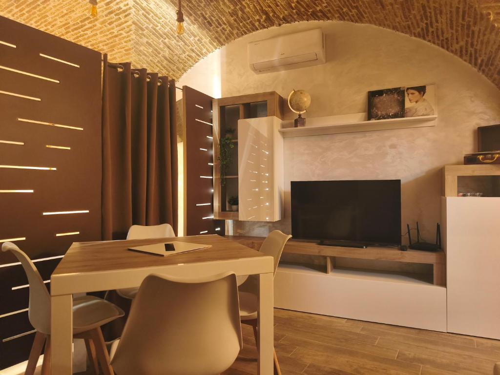 a dining room with a table and a tv at Mercato29Home in Lucera