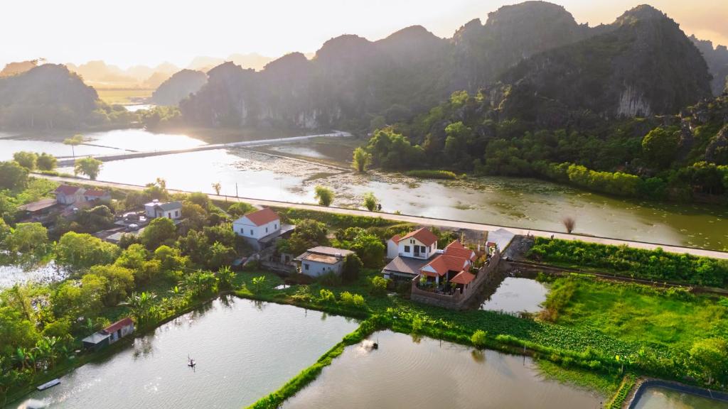 an aerial view of a river with houses and mountains at Cometa Villas Ninh Binh in Ninh Binh