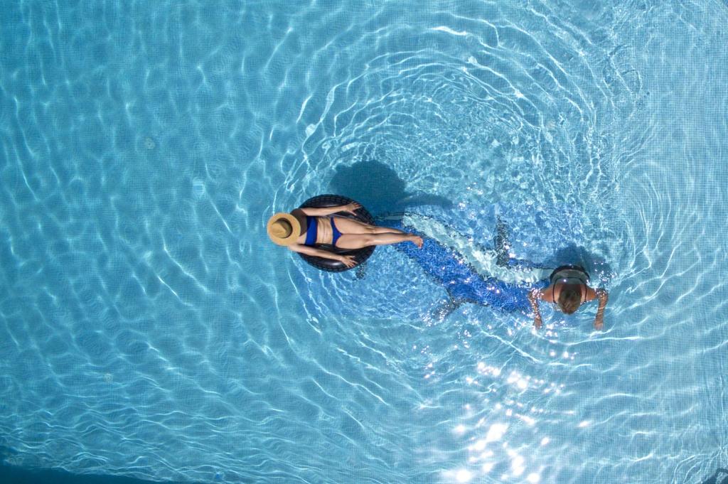 a person swimming in a pool of water at Hotel Evridiki in Fourka